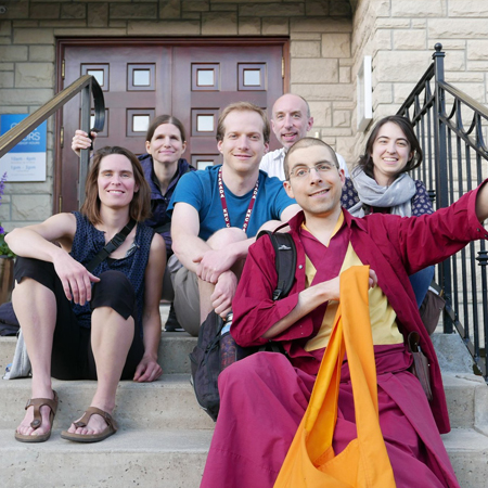 A group of happy people on the steps for the Kadampa Temple in Toronto