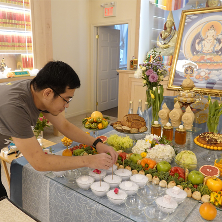A young man setting up shrine offerings