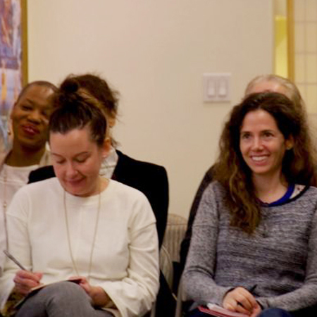 Students smiling while listening to a teaching on a Saturday Urban Retreat