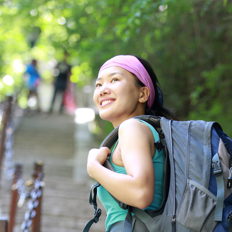 Oriental Woman smiling, hiking on trail