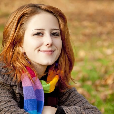 Smiling confident young woman sitting outside