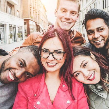 Several young people of diverse background posing for photo, smiling