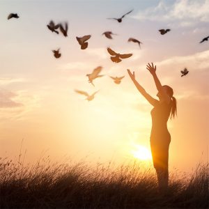 Woman in field releasing birds