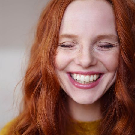 Beautiful young redheaded woman with very joyful facial expression