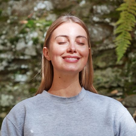 Beautiful young woman in nature, looking serene