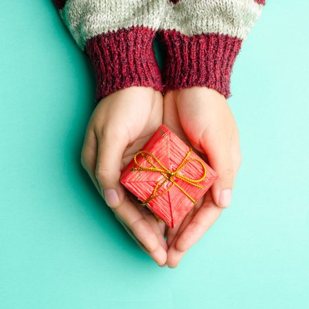 Two hands holding holiday gift